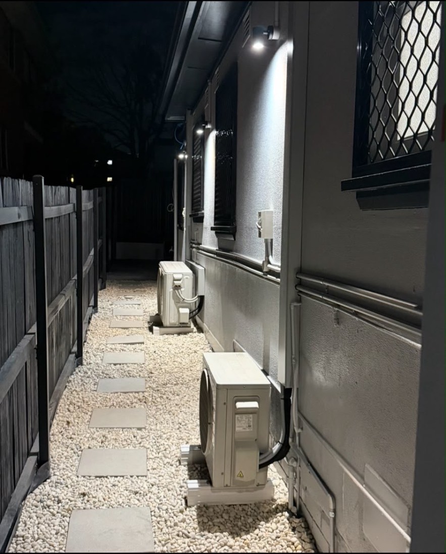 Multiple outdoor split system condensers installed along a finished side passage