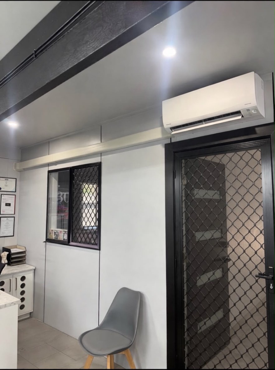 Completed wall-mounted split system installation in an office