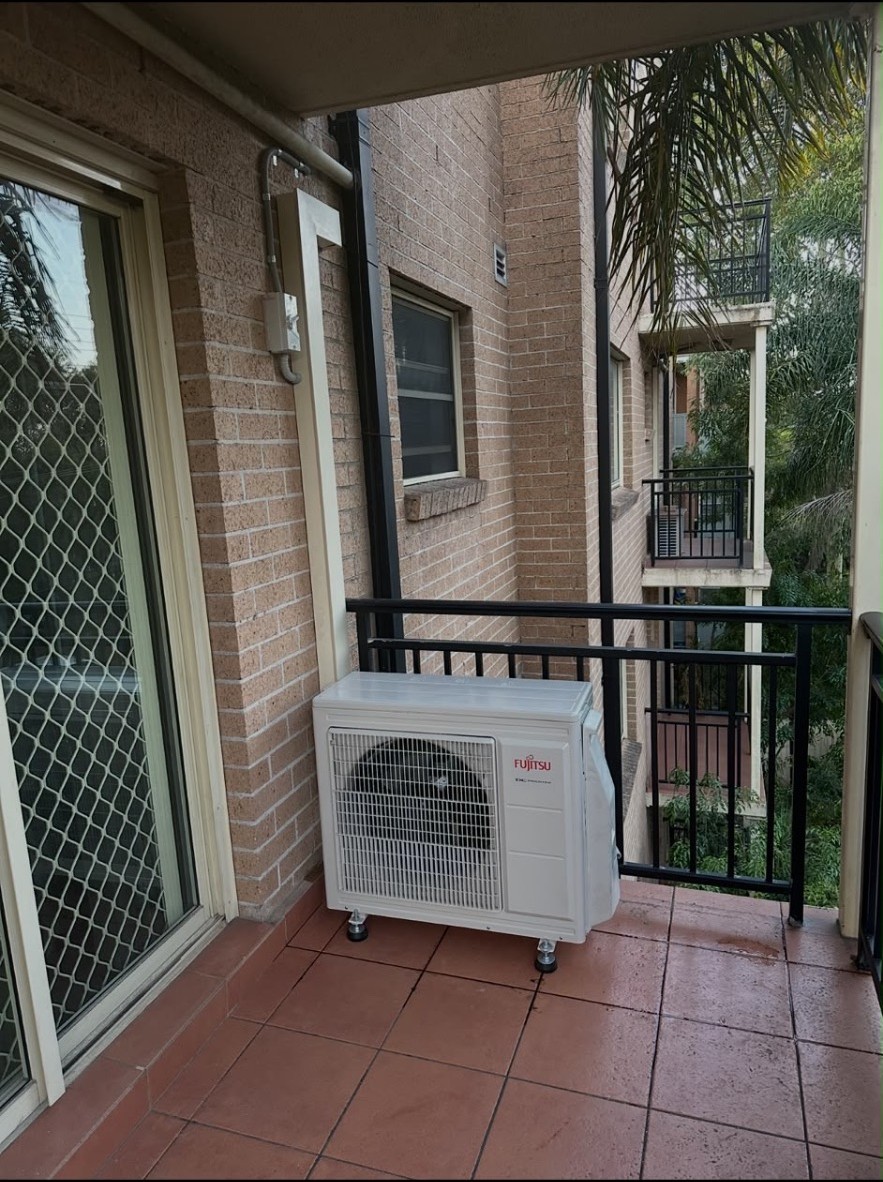 Fujitsu outdoor condenser professionally installed on a balcony